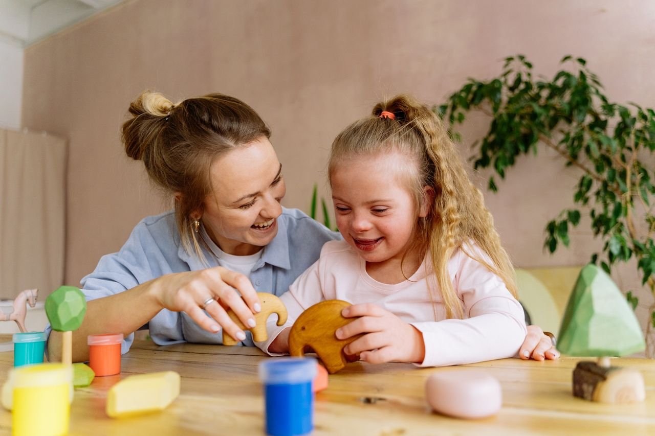 team-03 A joyful mother and daughter bonding while playing with toys indoors.