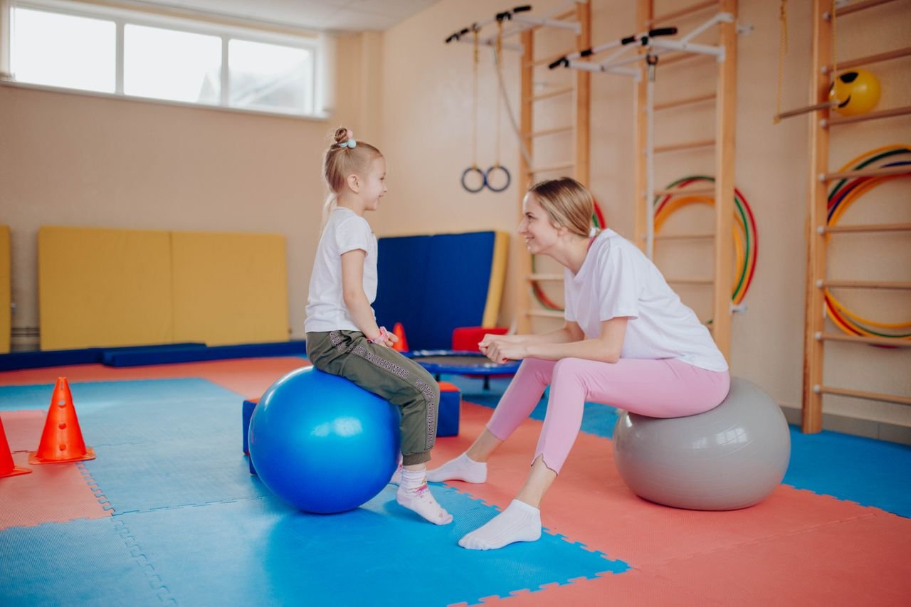 Mastering the First Impression: Your intriguing post title goes here Happy mother and daughter bonding on exercise balls in an indoor gym setting.